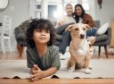 A child and a dog, on the floor, in front of parents. 