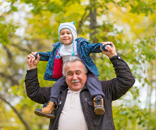 grandfather holding grandson on shoulders