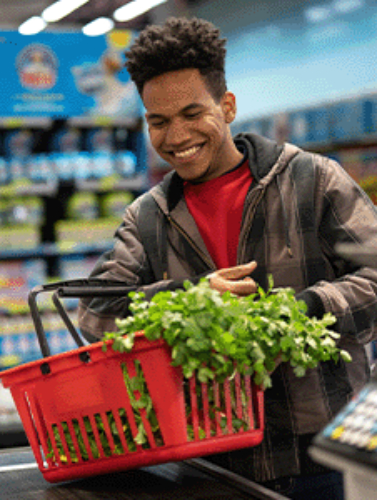 Man smiling while checking out at the grocery store.