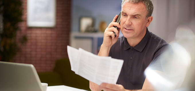 Man sitting at desk and talking on his phone