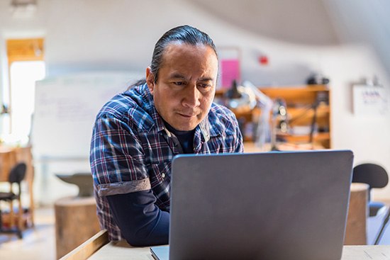 Man looks at a laptop screen.