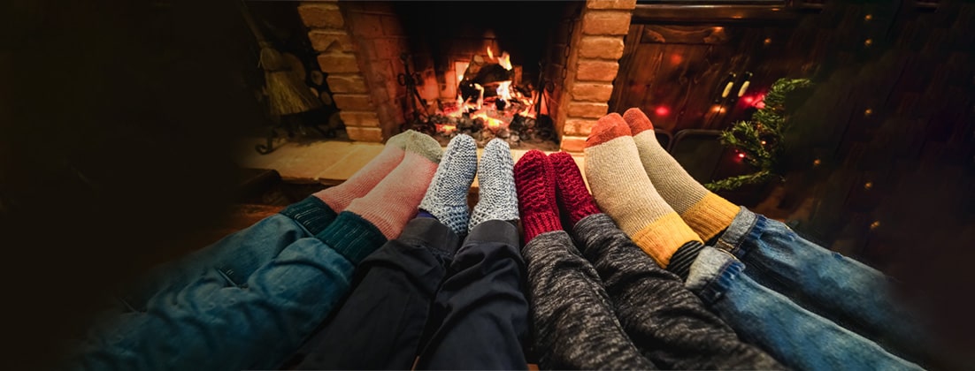 Feet in cozy socks in front of a fireplace