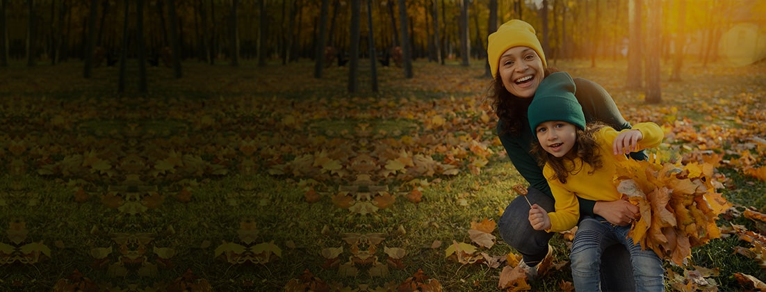 Mother and daughter enjoying autumn leaves 