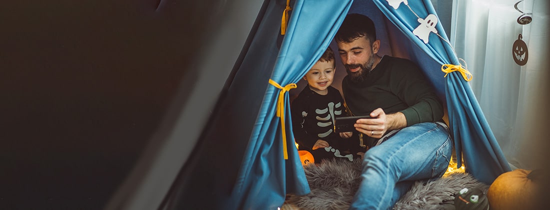 Father and son read a Halloween story.