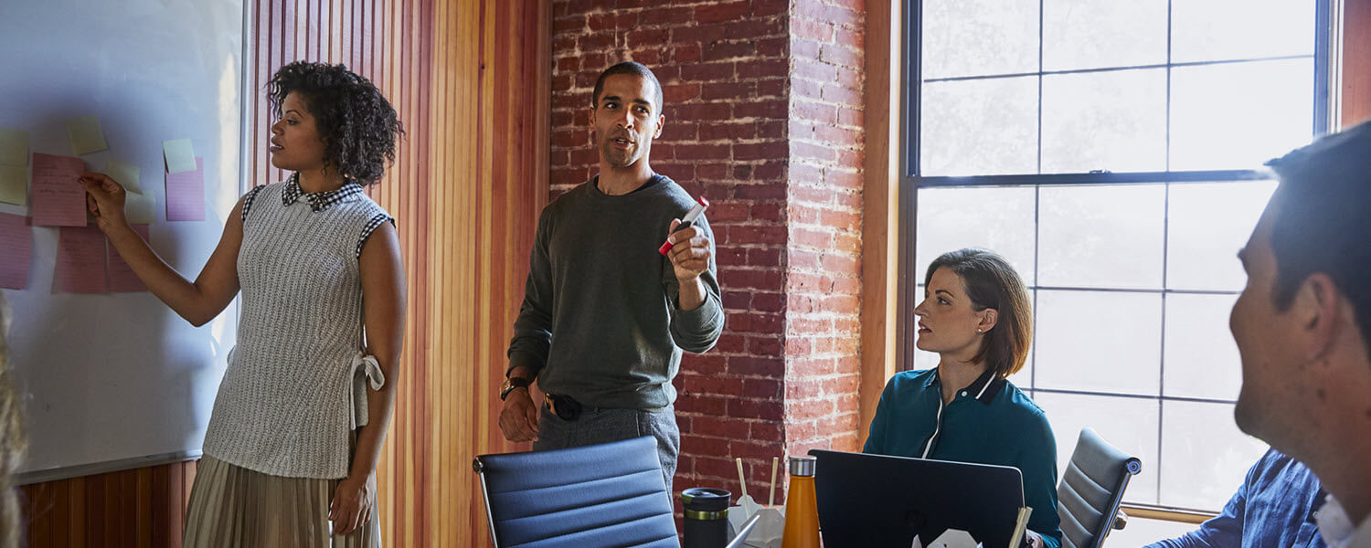 Employees working together at a whiteboard