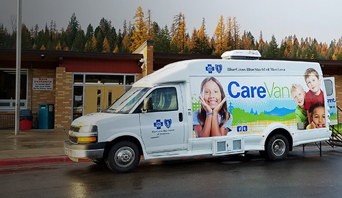 Care Van parked on pavement near community center.