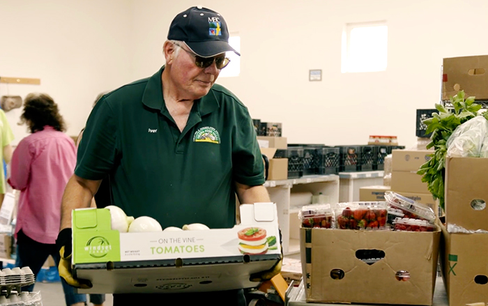 Worker carries a box of food for a hunger-relief program.