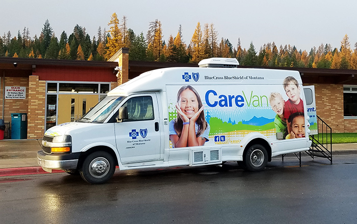 Care Van parked on pavement near community center.
