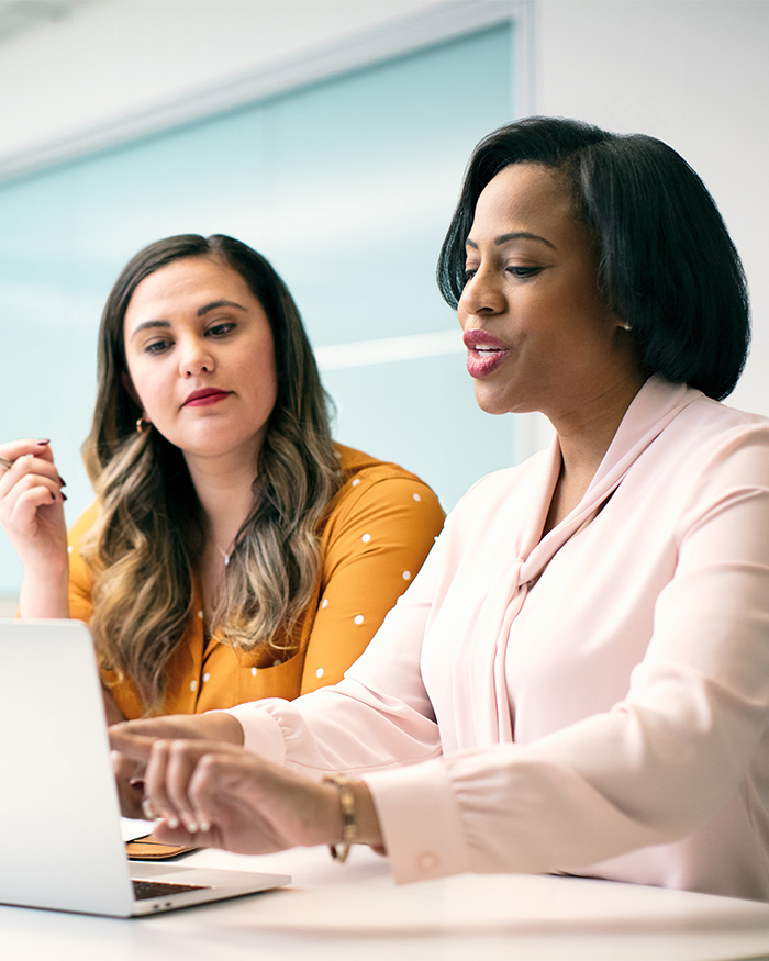 Two well-dressed women discuss business.