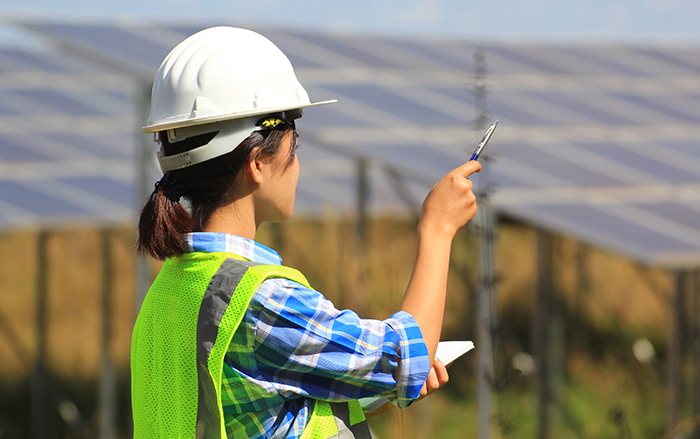 Female engineer overseeing solar panels