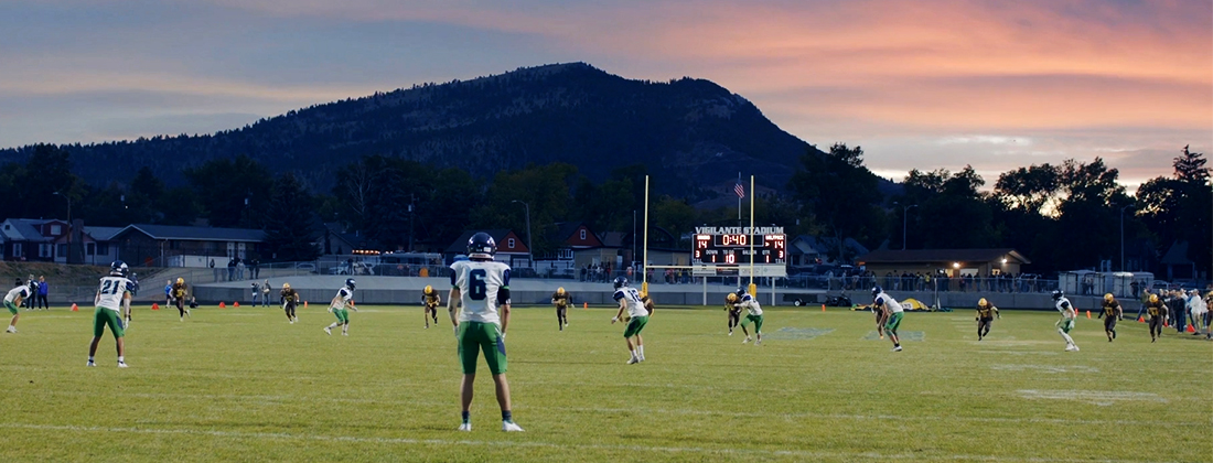 Evening football game with mountains in background
