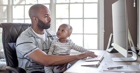Image of man with baby on a computer