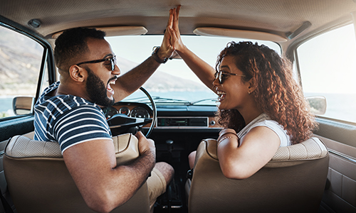 Couple high fiving in the car after enrolling in health insurance