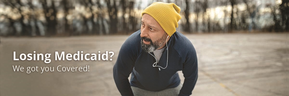 Man wearing headphones and winter hat, jogging outside in the park